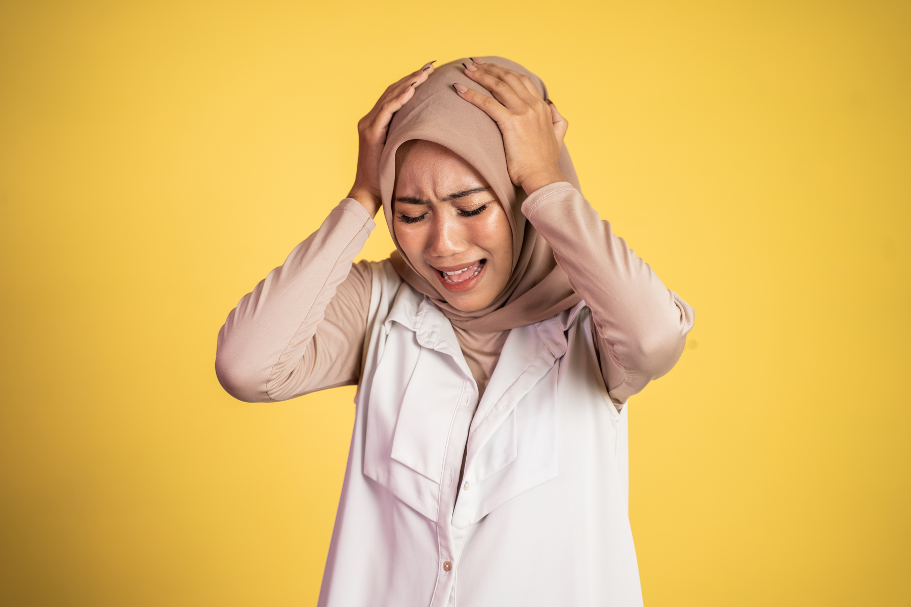 Asian Woman in Hijab Holding Head with Headache